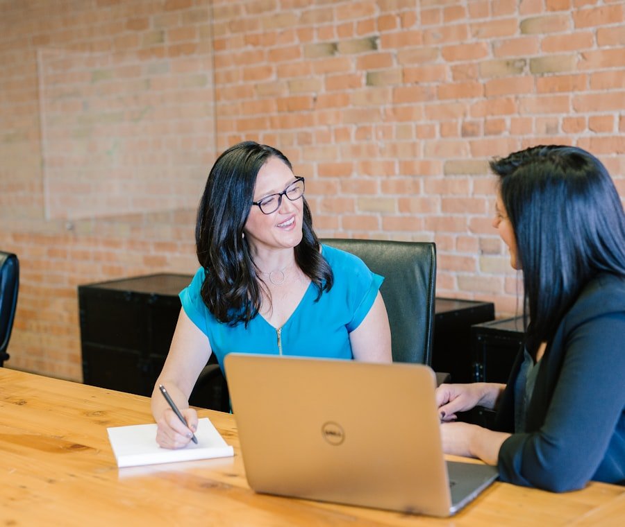 Two professionals talking through paperwork at a table